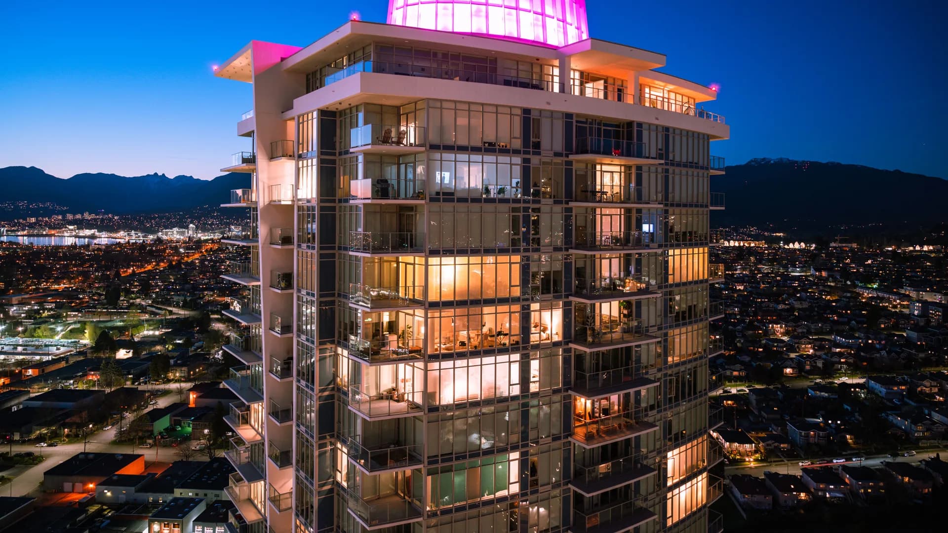 A lit residential tower in Burnaby at twilight