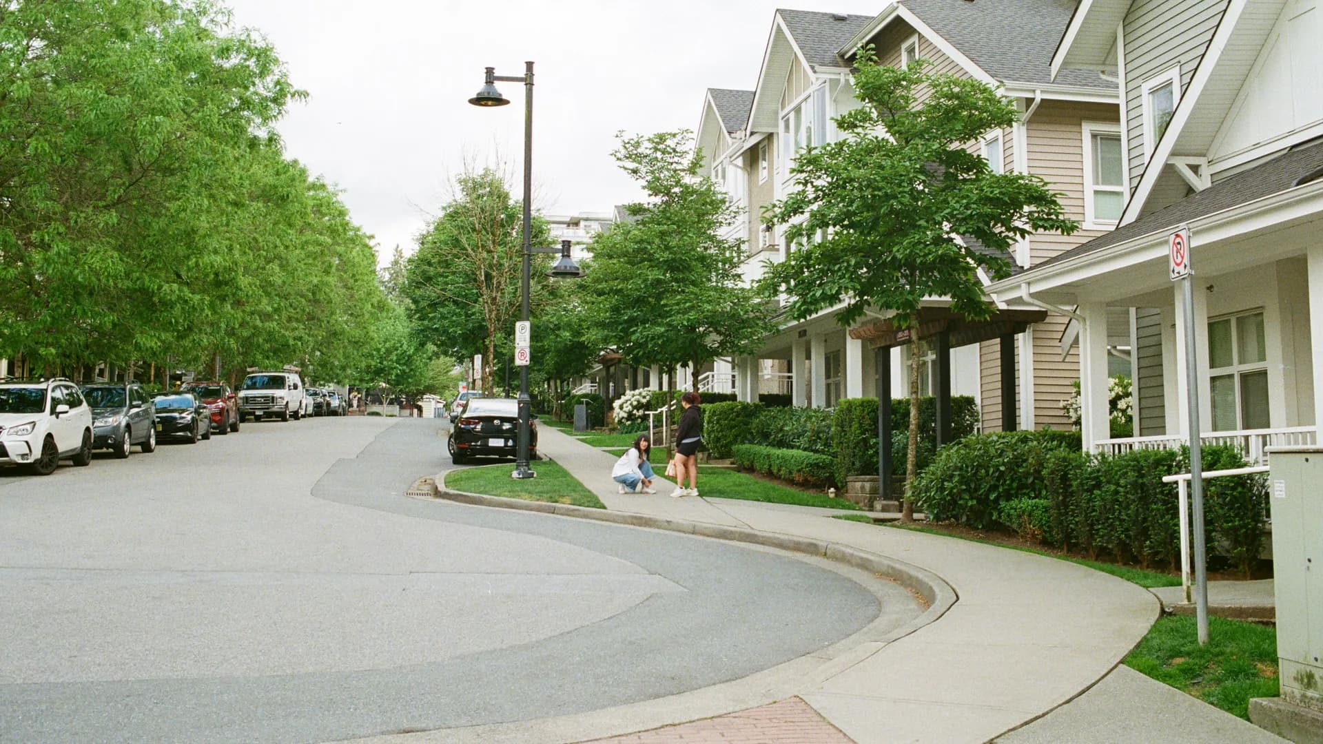 A tree-lined residential street of townhouses in Vancouver on an overcast day